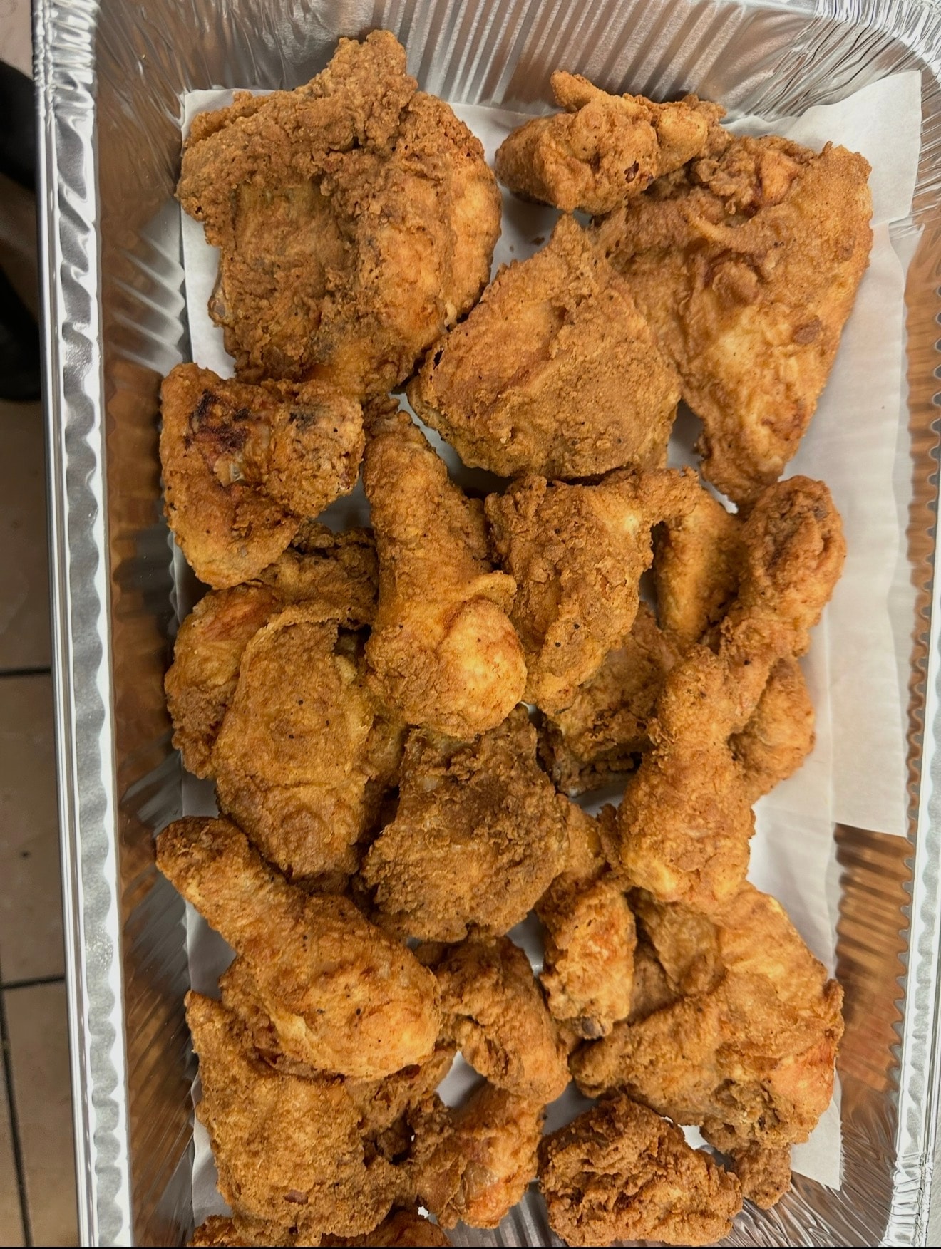 Close-up tray of golden fried chicken prepared for Eatz Grill catering